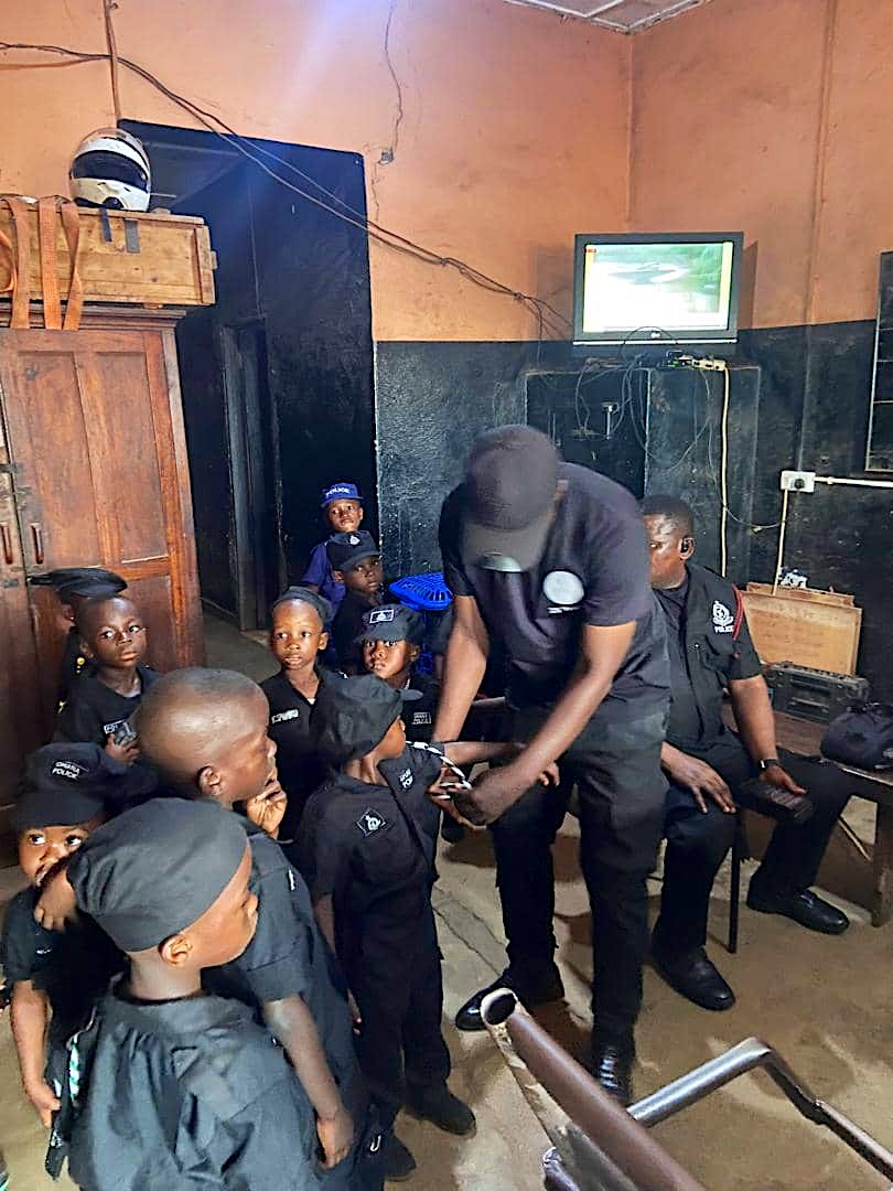 Learners in police costumes at a police station