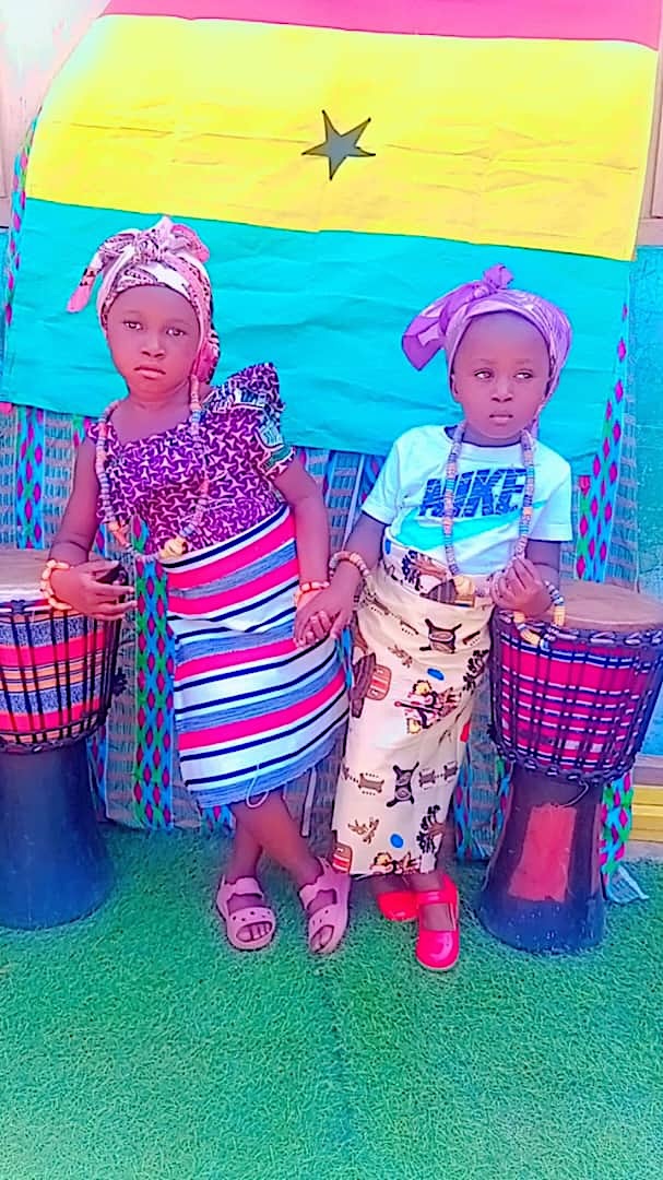 Two girls in traditional dress with drums
